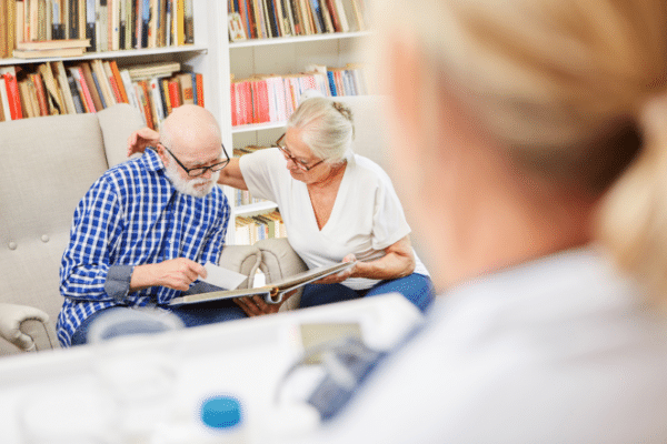 Family caregiver and loved one with dementia looking at a photo album.