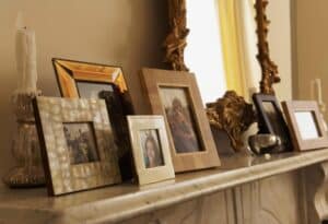 Family photos in a marble fireplace.