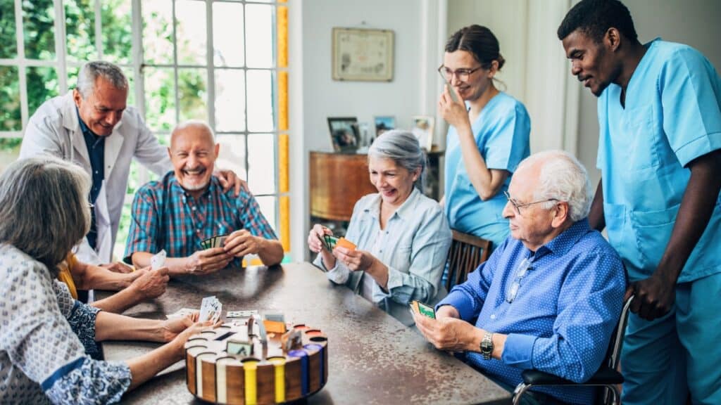 Groups of seniors in assisted living playing cards.