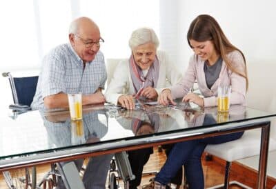 Senior-parents-playing-puzzle-with-their-daughter.