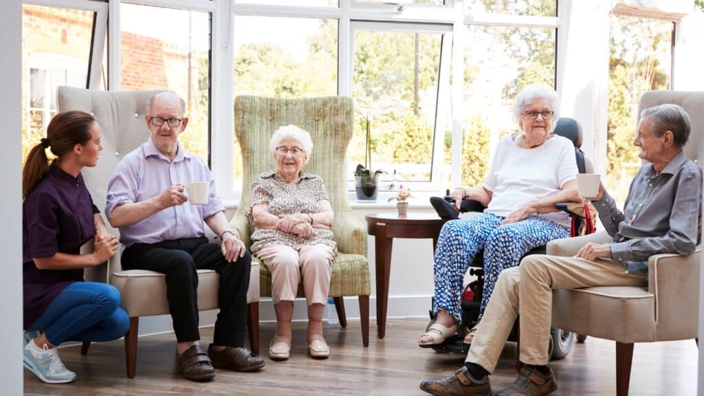Seniors with a caregiver in an assisted living community.