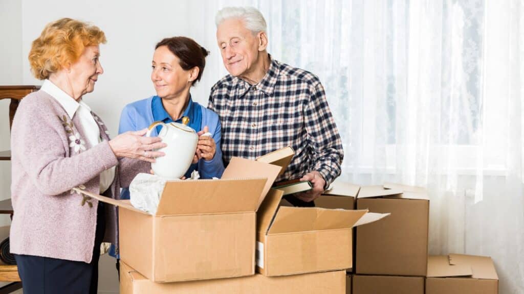 Seniors parents and daughter are helping together to pack things.