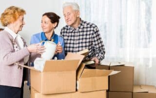 Seniors parents and daughter are helping together to pack things.