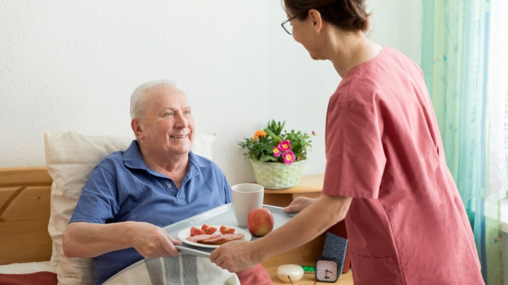 Caregiver helping senior in level 3 in assisted living.