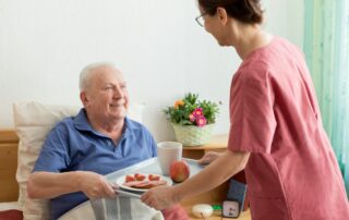 Caregiver helping senior in level 3 in assisted living.