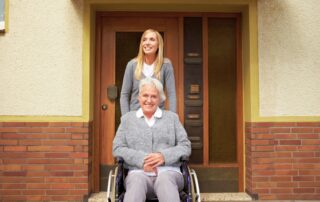 Caregiver and smiling senior woman in a wheelchair eligible for assisted living facility.