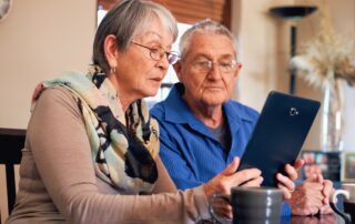 Senior couple using a tablet searching for assisted living.