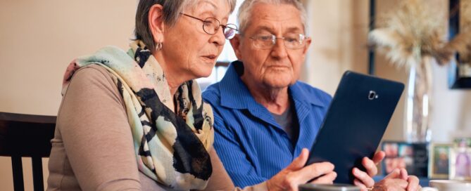 Senior couple using a tablet searching for assisted living.