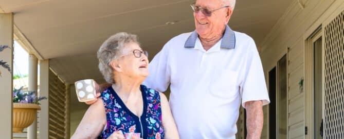 Senior couple holding mugs living in an independent living community.