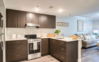 Grand Villa of Sarasota apartment kitchen with stainless steel appliances and hardwood floors.