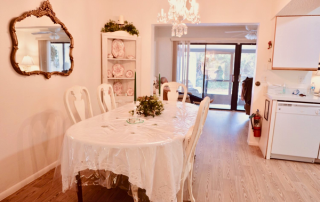 Harbor Inn of Venice South dining room with a white long table and chairs.