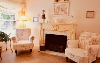 Harbor Inn of Venice South living room with two chairs and a fireplace.