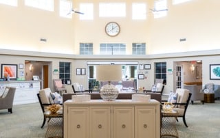 The lobby of a Heron House Sarasota with a clock on the wall.