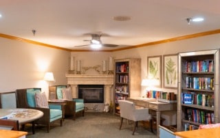 Heron House Sarasota living room with a fireplace and bookshelves.