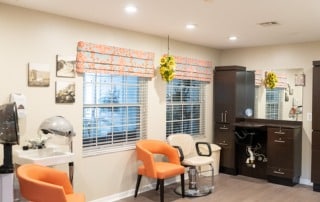 Heron House Sarasota salon room with orange chairs and a hair dryer.