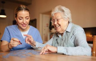 Companion caregiver playing puzzle with a senior.