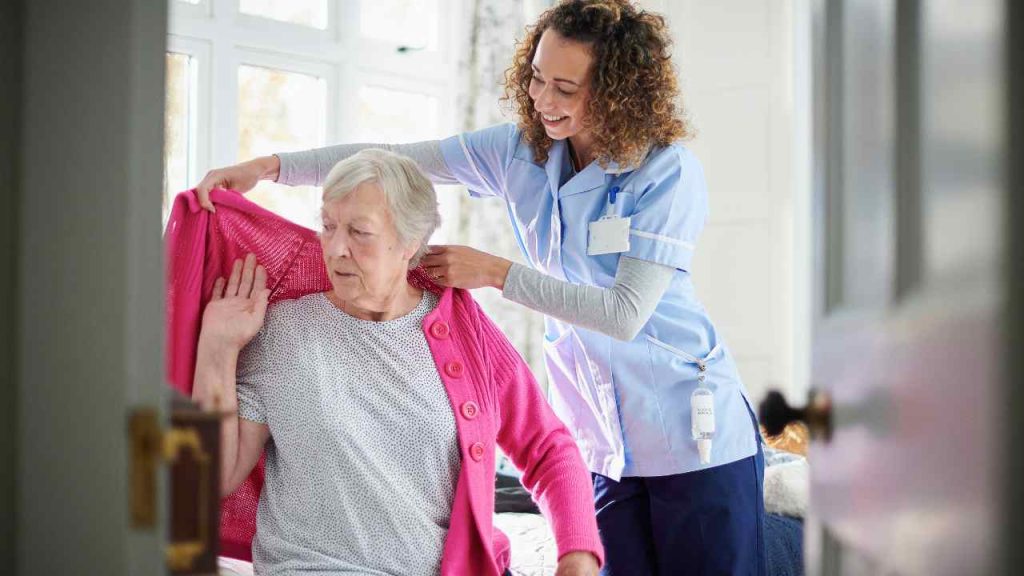 Caregiver helping Senior in a Continuing Care Retirement Community (CCRC).