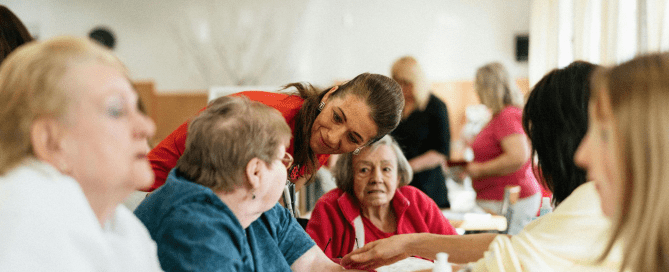 A woman talking to a group of senior women.