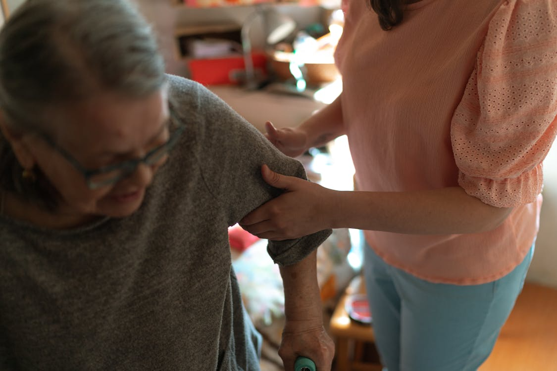 A person helping an elderly person.