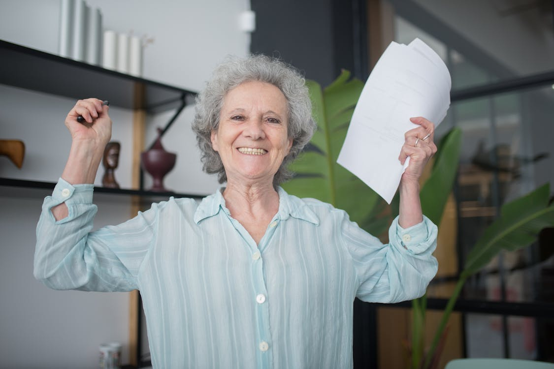An elderly person in a teal button-up shirt 