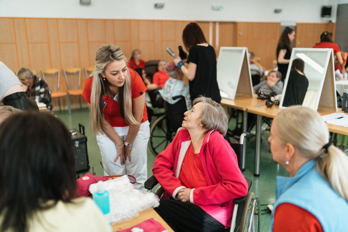 A caregiver attending to elderly people in wheelchairs