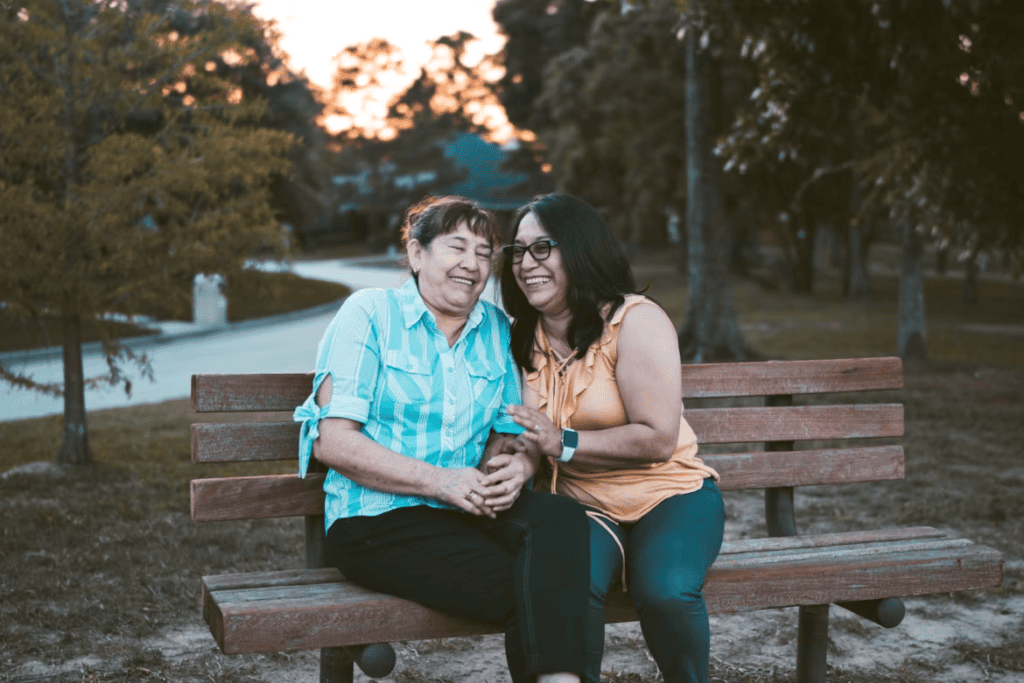 A person with their elderly parent on a bench