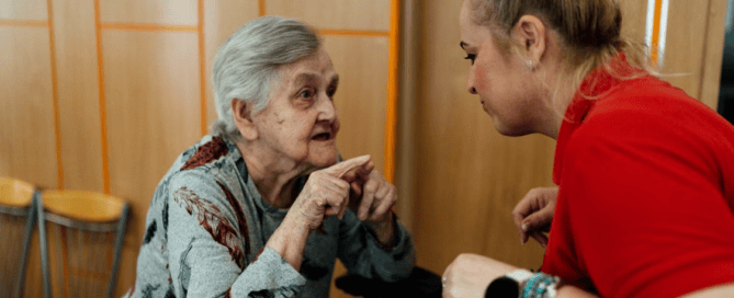 An elderly person talking to a caregiver