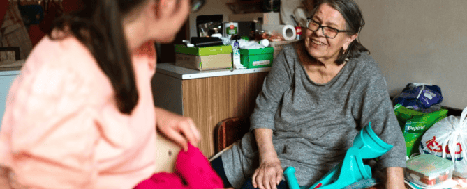 A caregiver talking to an elderly person