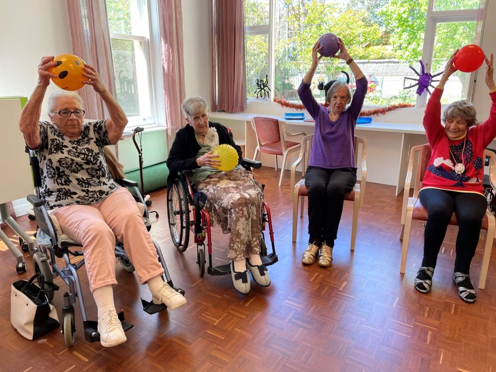 People holding balls and sitting in wheelchairs