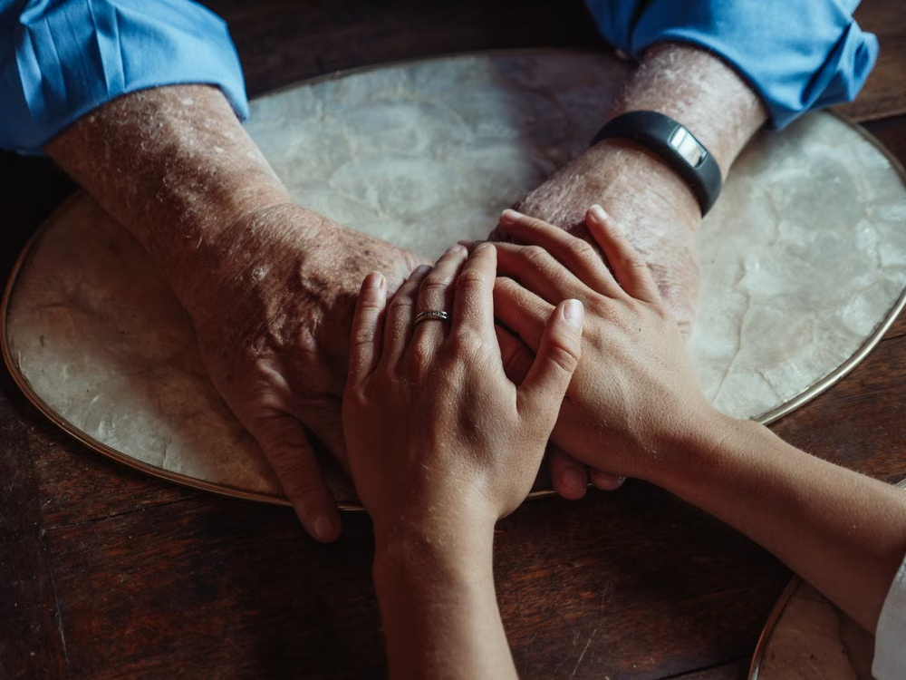 A person holding a senior’s hands