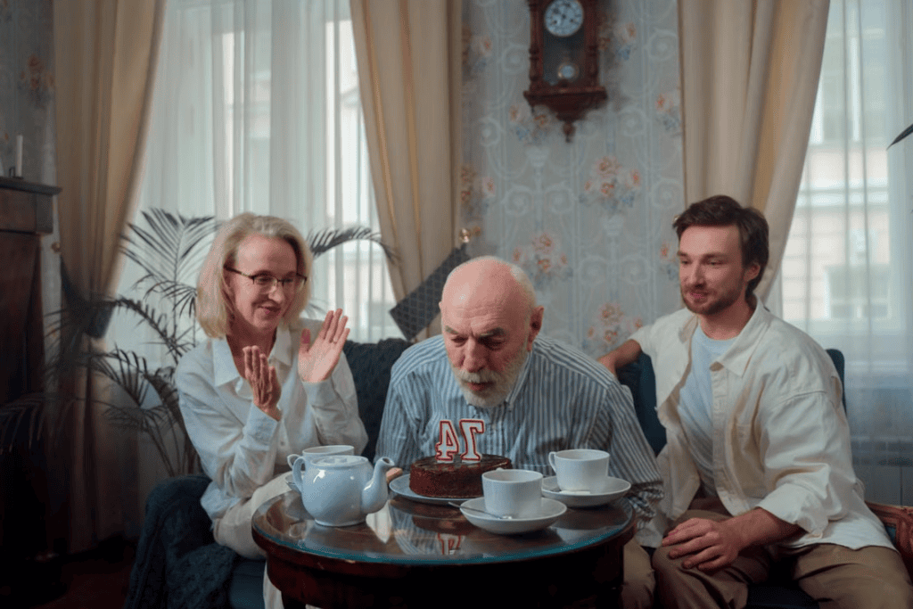 An elderly person celebrating their birthday with their family