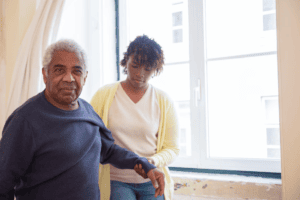 A caregiver holding the arm of an elderly person 