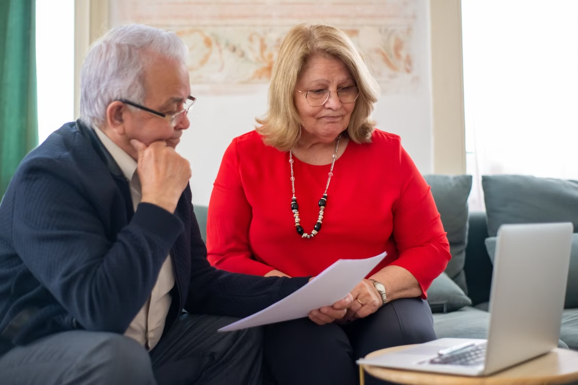 An elderly couple reviewing documents together at home