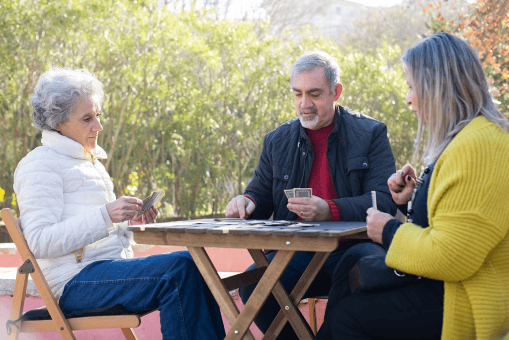 A group of seniors playing cards together outdoors