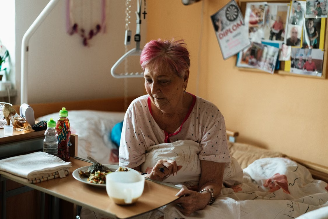 An elderly person having a meal in bed